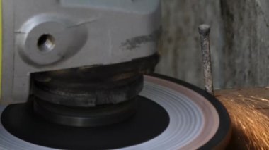Öğütücüye yaklaşın. Sert çiviyi keserken kıvılcımlar saçar.