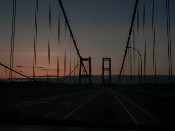Estrecha el puente con el tráfico que fluye a lo largo al atardecer — Foto de Stock