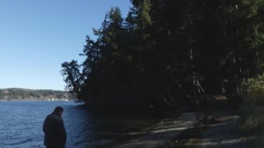 Puget Sound 'un karanlık kıyı şeridi boyunca yalnız bir adam
