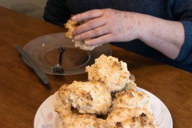 Yaşlı kadın yemek hazırlıyor ve eğleniyor.