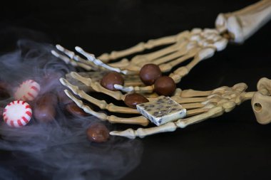 İskelet eller şeker ve kuru buz dumanı tutuyor.