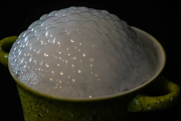 Bubbles on top of a green container on black — Stock Photo, Image