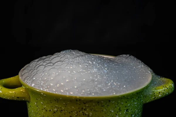 Suds filling a container on a black background — Stock Photo, Image