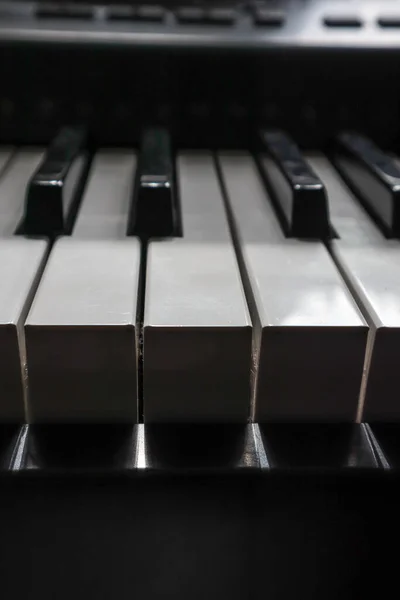 Keys of a piano in dark shadow and bright light — Stock Photo, Image