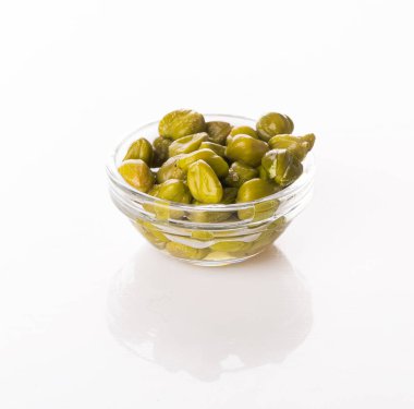 Beyaz arka planda izole edilmiş şeffaf bir kasede kapari.