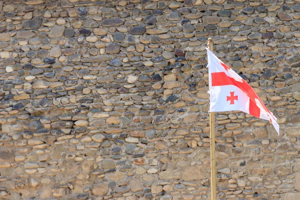 Georgian flag against old fortress wall