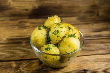 Tereyağı ve ahşap masa üzerine dereotu ile yeni haşlanmış patates