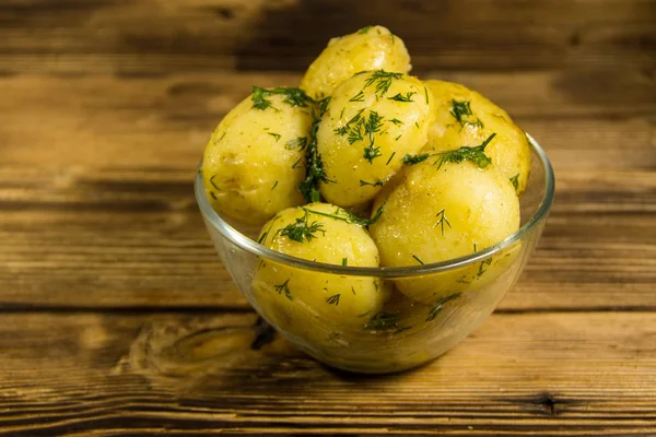 Tereyağı ve ahşap masa üzerine dereotu ile yeni haşlanmış patates