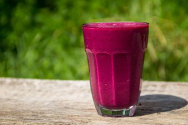 Cam berry güler yüzlü rustik ahşap tablo üzerinde arka plan bulanık. Sağlıklı yaz içki kavramı. Berry kokteyl