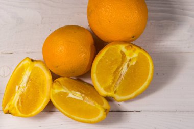 Beyaz ahşap masada taze portakallar.