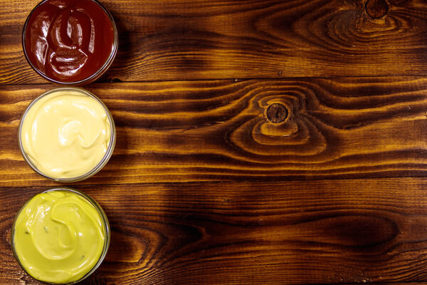 Набор соусов на деревянном столе. Вид сверху, пространство для копирования