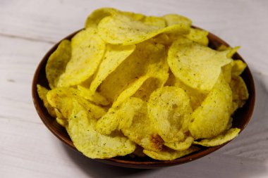 Beyaz ahşap masada patates cipsi tabağı