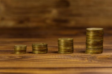 Ahşap zemin üzerine altın sikke yığını. İş kavramı