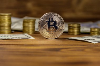 Gümüş bitcoin ve ahşap arka planda dolar