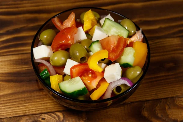 ギリシャ風サラダ新鮮な野菜 木製のテーブルにガラスのフェタ チーズ グリーン オリーブ ボウルします — ストック写真