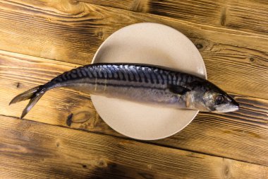 Scomber balık bir plaka üzerinde tuzlu. Ahşap masa üzerinde tüm uskumru
