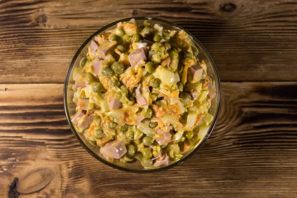 Sosis, bezelye, havuç ve soğan ahşap masa üzerinde mayonez salatası. Üstten görünüm