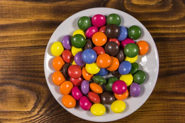 Platillo Con Coloridos Caramelos Forma Botón Llenos Chocolate Mesa Madera — Foto de Stock