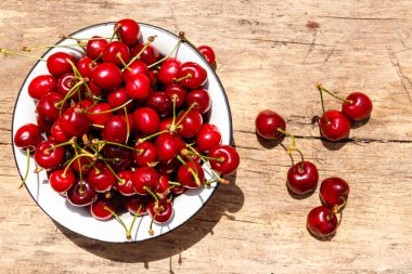 Rustik ahşap masa üzerinde taze olgun kiraz ile top. Üstten görünüm