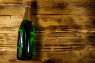 Ahşap arka plan üzerinde şampanya şişesi. Üstten görünüm, kopya alanı