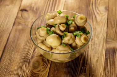 Cam kase salamura petrol ile. Ahşap masa üzerinde Marine mantar