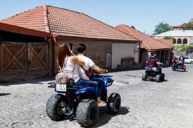 Sighnaghi,: Kakheti, Georgia - 2 Mayıs 2018: tüm arazi aracı Ortaçağ kenti Sighnaghi Caddesi üzerinde sürme mutlu turistler. Quad bisiklet üzerinde heyecanlı genç insanlar. Atv gezisi