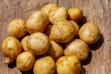 Rustik ahşap masa üzerinde ham yeni patates. Üstten görünüm