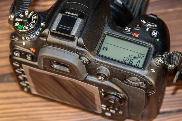 Professional digital photo camera on wooden background close-up