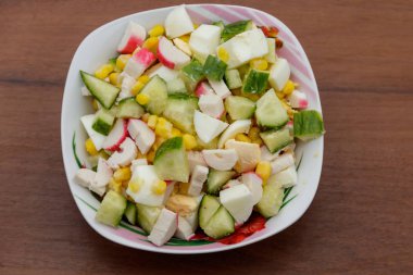 Yengeç sopa, tatlı mısır, salatalık ve ahşap masa üzerinde yumurta salatası. Üstten Görünüm