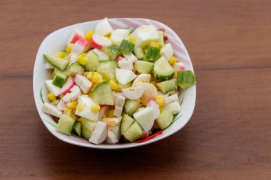 Yengeç sopa, tatlı mısır, salatalık ve ahşap masa üzerinde yumurta salatası. Üstten Görünüm