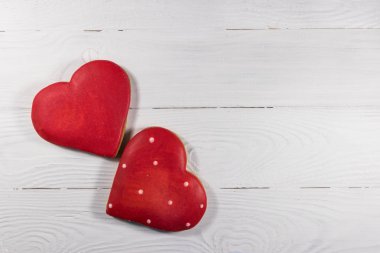 Beyaz ahşap masada sevgililer günü için kalp şeklinde kurabiyeler. Üst görünüm, alanı kopyala