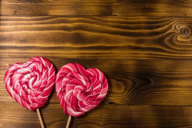 Lolipop ahşap arka plan üzerinde iki kalp şeklinde