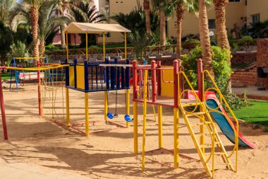 Tropikal tatil beldesindeki çocuklar için renkli oyun alanı ekipmanları