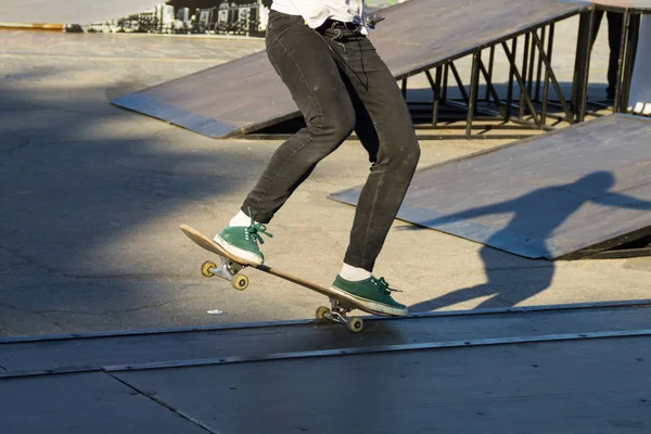 Gambe da skateboarder cavalcando skateboard allo skatepark — Foto Stock