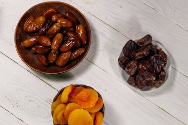 Kurumuş kayısılar ve beyaz ahşap masada meyveler. Üst görünüm