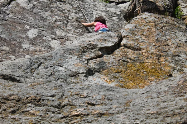 Девушка-скалолаз забирается на скалу — стоковое фото