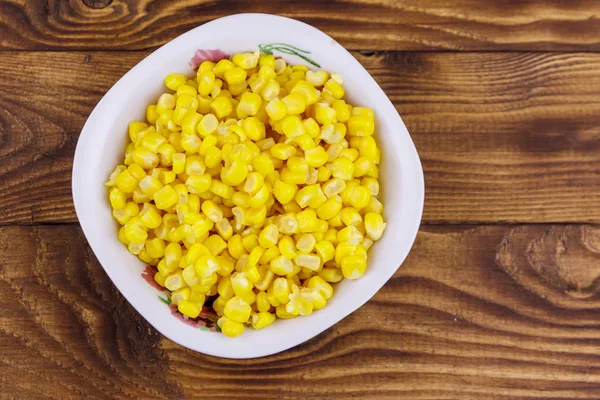 Canned sweet corn in a bowl on wooden table — Stock Photo, Image