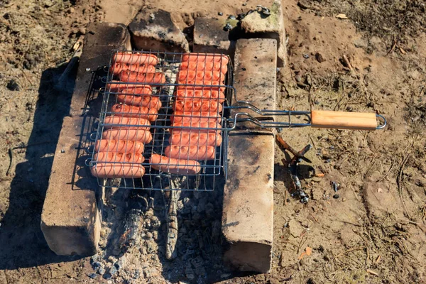 Grelhar salsichas em churrasco grelhar cozinhar na fogueira — Fotografia de Stock