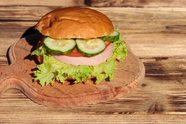 Fresh delicious homemade burger on wooden table — Stock Photo, Image