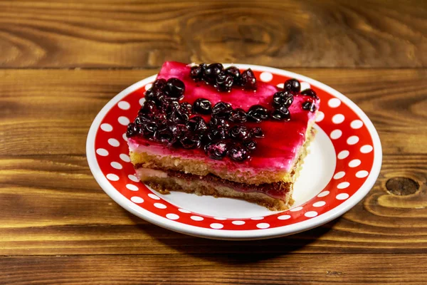 Tasty cheesecake with black currant on wooden table — Stock Photo, Image