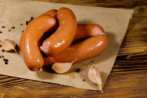 Worstjes op bruin papier op houten tafel — Stockfoto