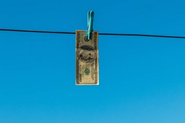 Çamaşır ipinde asılı 100 dolarlık banknot. Kara para aklama kavramı