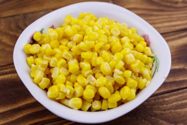 Ahşap masa üzerinde bir kase konserve mısır