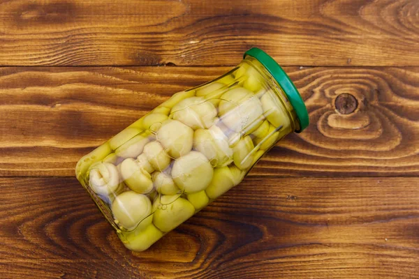 Delicious marinated mushrooms in glass jar on wooden table — Stock Photo, Image