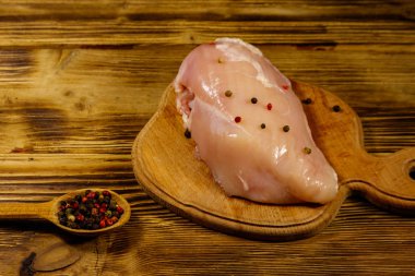 Ahşap masa üzerinde kesme tahtası üzerinde Çiğ tavuk göğsü