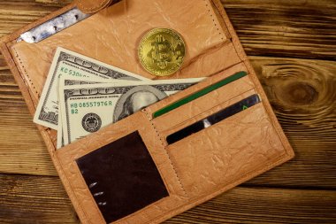 Ahşap arka plan üzerinde amerikan yüz dolar banknotlar ve altın bitcoin ile Cüzdan
