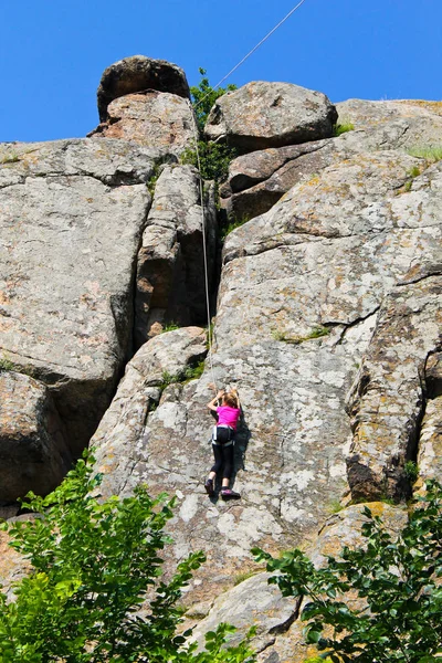 Ragazza arrampicatore arrampica su una roccia — Foto Stock