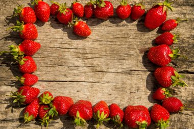 Taze kırmızı çilek çerçevesi ahşap masa üstünde fotokopi alanı manzaralı.