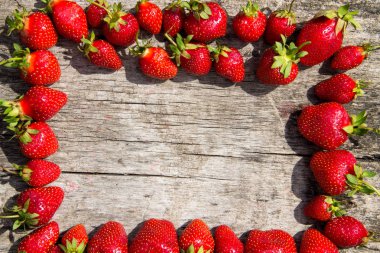 Taze kırmızı çilek çerçevesi ahşap masa üstünde fotokopi alanı manzaralı.