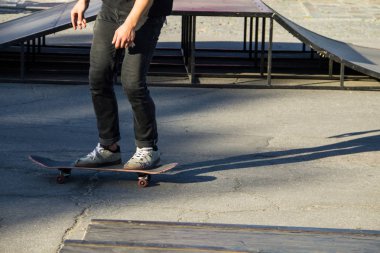 Kaykaycı bacakları kaykay parkında sürüyor. 